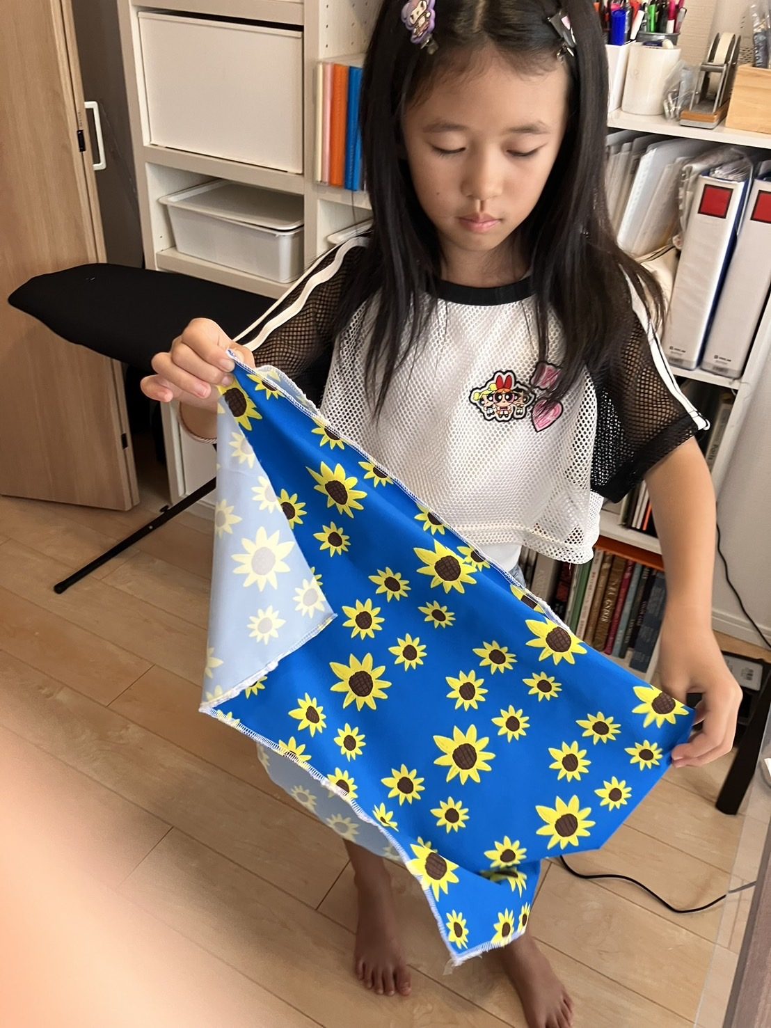 自分がデザインした柄の布を広げている子ども